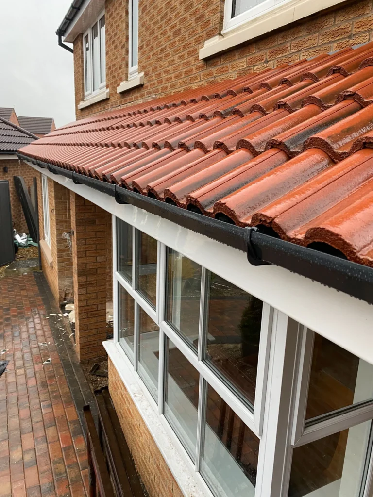 Brick house with red clay tile roof and white windows