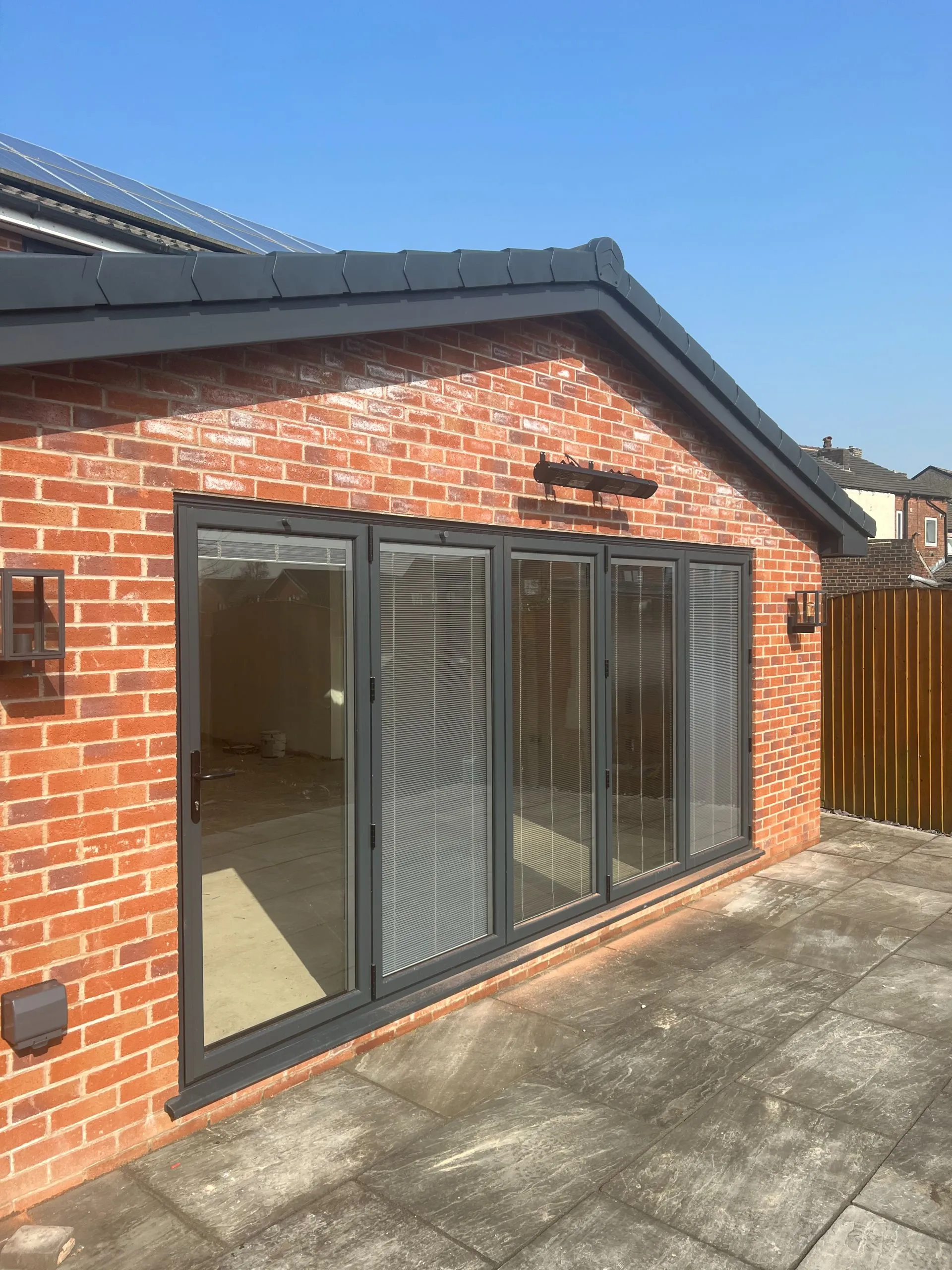 Modern brick garden room with grey aluminium bi-fold doors