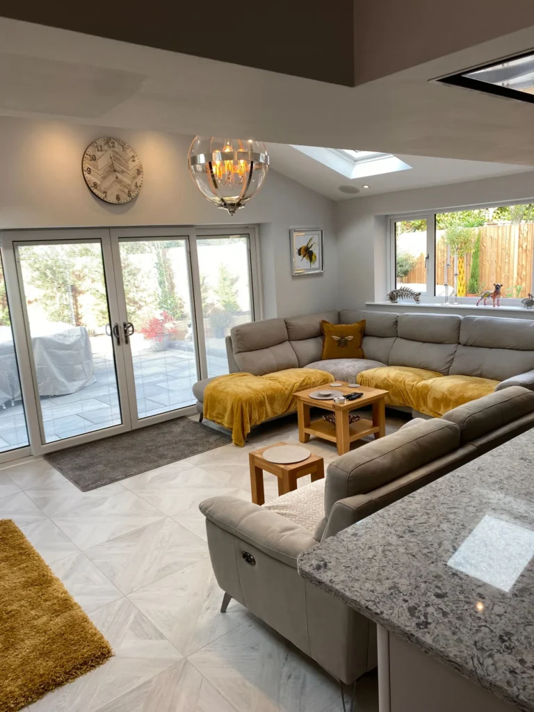 Modern living room with grey corner sofa, golden accents, skylights