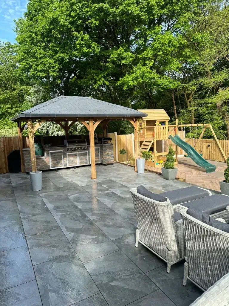 Garden patio with wooden gazebo, barbecue, and playhouse